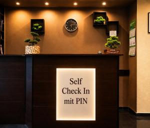 Ein Schild mit der Aufschrift „Selbst-Check-in Mr. Pin“ an einer Wand in der Unterkunft Hotel Stadion Stadt in Hamburg