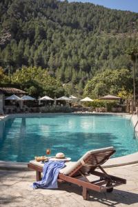a table and a chair next to a swimming pool at Es Moli Hotel in Deia