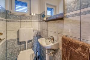 a bathroom with a toilet and a sink at Apartments Celebrini in Malinska +17 photos