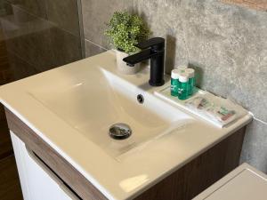 a white bathroom sink with a black faucet at Apartment Near Zadar Airport & City in Crno +6 photos