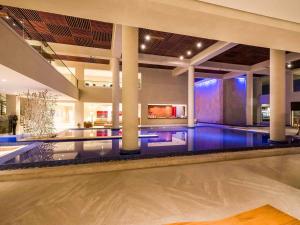 a swimming pool in a large building with a swimming pool at Hotel Jequitimar Guaruja Resort & Spa by Accor in Guarujá +129 photos
