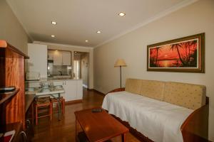 a living room with a couch and a kitchen at FLH Monte Gordo Balcony Flat in Monte Gordo