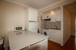 a kitchen with a white counter and a microwave at FLH Monte Gordo Balcony Flat in Monte Gordo