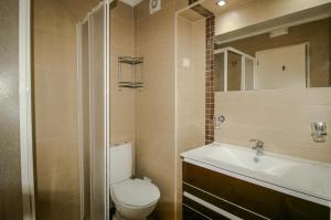 a bathroom with a toilet and a sink and a mirror at FLH Monte Gordo Balcony Flat in Monte Gordo +4 photos