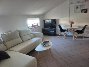 a living room with a couch and a table at Apartment Vdovjak in Malinska