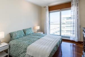 a bedroom with a bed and a large window at SEAMatosinhos in Matosinhos