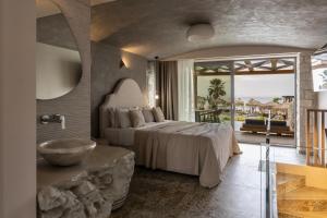 a bedroom with a bed and a bathroom with a sink at Blue Carpet Luxury Suites in Pefkochori +183 photos