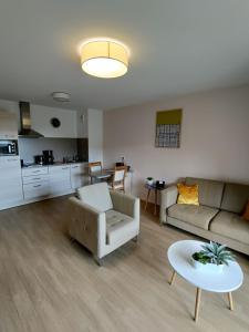 a living room with a couch and a table at Domitys Le Griffon d’Or in Saint-Brieuc