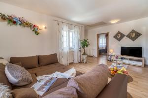 a living room with a couch and a television at Apartments Celebrini in Malinska