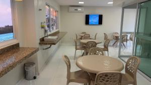 a dining room with tables and chairs and a tv at Vila Mar Eco Hotel in Parnaíba