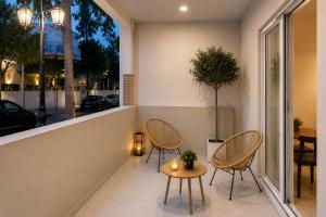 a patio with two chairs and a table and a window at United Cretan Villas Boutique Studio in Agia Marina Nea Kydonias