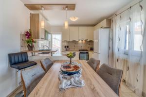 a kitchen and dining room with a wooden table and chairs at Apartments Celebrini in Malinska