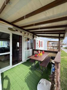 an outdoor patio with a wooden table and green grass at Casa da Agueira AC1 in Pataias