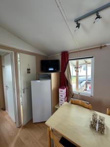a kitchen with a table and a refrigerator at Casa da Agueira AC1 in Pataias