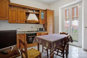 a kitchen with a table and chairs and a table and a stove at Terrazza nel Vigneto - Free parking in Tellaro