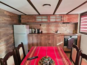 a kitchen with a table with a red table cloth at Вила ОРЕХИТЕ in Dupnitsa