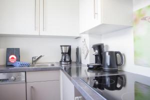 a kitchen with white cabinets and a counter top at Welcome in - Ferienwohnung 59-W in Winterberg mit Balkon und Schwimmbad in Winterberg