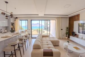 a living room with a couch and a bar with stools at Sharksproperties Luxury 3BR Ocean View Apartment with Rooftop Pool 6 Guests in Mindelo