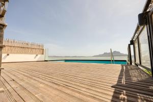 a wooden deck with a view of the water at Sharksproperties Luxury 3BR Ocean View Apartment with Rooftop Pool 6 Guests in Mindelo