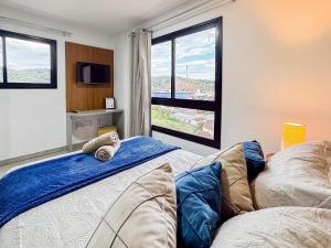 a bedroom with two beds and a large window at Apto no coração de Brusque in Brusque