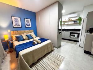 a bedroom with a bed with a blue wall at Apto no coração de Brusque in Brusque