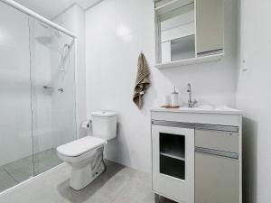 a bathroom with a toilet and a sink and a shower at Apto no coração de Brusque in Brusque +14 photos