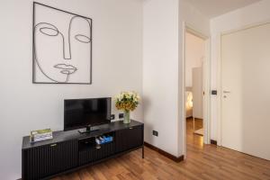 a living room with a television and a vase of flowers at Bebyme - EPICENTRUM in La Spezia