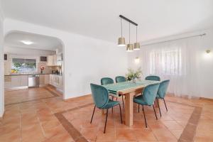 a dining room with a table and green chairs at Modern Villa In Olhao in Quelfes +22 photos