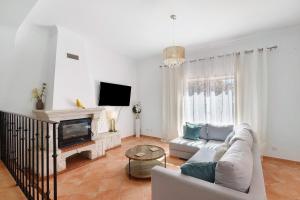 a living room with a couch and a tv at Modern Villa In Olhao in Quelfes
