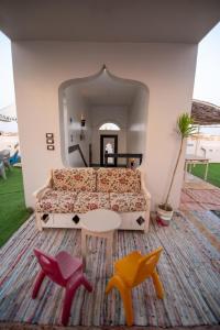 a living room with a couch and some colorful stools at Sunny sea in Quseir