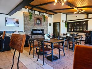 a restaurant with tables and chairs and a fireplace at For-Rest Inn and Spa in Bathurst