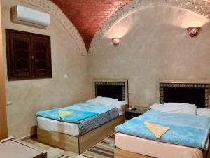 two beds in a room with a ceiling at King Siwa in Siwa +34 photos