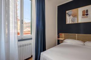 a bedroom with a bed and a large window at Bebyme - EPICENTRUM in La Spezia
