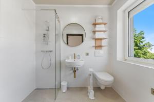 a bathroom with a toilet and a sink and a mirror at Air Linz Residence in Linz +42 photos