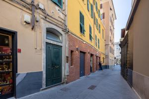 a narrow alley with a green door on a building at Bebyme - EPICENTRUM in La Spezia