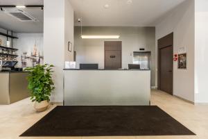 a lobby with a counter and a potted plant at Hotel Aquila D in Durrës