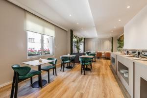 a restaurant with green chairs and tables and a kitchen at Hotel Aquila D in Durrës