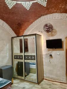 a room with a glass cabinet with a tv on a ceiling at King Siwa in Siwa