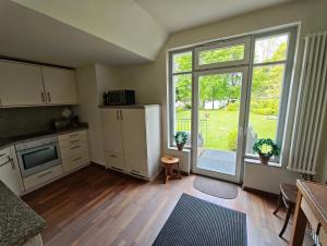 a kitchen with a large window and a table and chairs at Trentsee Chalet in Malente