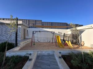 a backyard with a playground with a swing at Olives Hill Farm in Al Kufayr