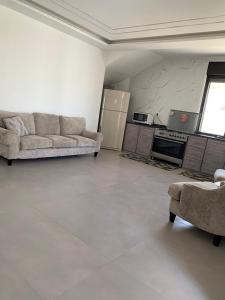 a living room with a couch and a kitchen at Olives Hill Farm in Al Kufayr
