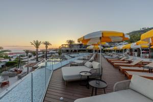 a balcony with tables and chairs and umbrellas at Aldiana Club Rocca Nettuno Calabria in Tropea