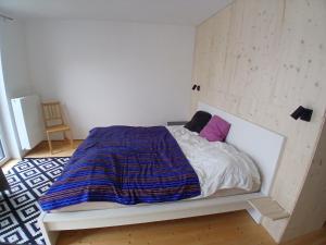 a bedroom with a bed with a blue and white comforter at Wein4tel Auszeit in Blumenthal