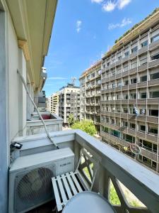 a balcony with a television and a building at Alpha - City Center Rooms Athens in Athens
