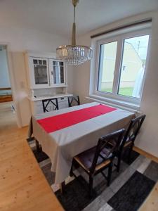 a dining room with a table with chairs and a chandelier at Wein4tel Auszeit in Blumenthal +8 photos
