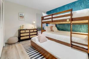 a bedroom with two bunk beds and a desk at Casa Marco - Heated Pool, Game Room, Mini Golf in Marco Island