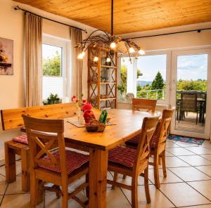 a dining room with a wooden table and chairs at EulenHorst - Ferienhaus in Seeboden am Millstätter See mit Sonnenterasse & Bergblick in Seeboden