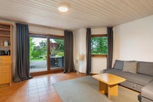 a living room with a couch and a table at Haus Ersfeld – Gartenwohnung in Bad Teinach-Zavelstein