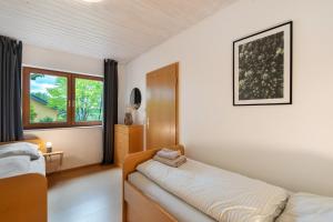 a bedroom with two beds and a window at Haus Ersfeld – Gartenwohnung in Bad Teinach-Zavelstein