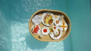 a tray of food on a table next to a swimming pool at Ayodhya Villa Utari - South Wings in Yogyakarta